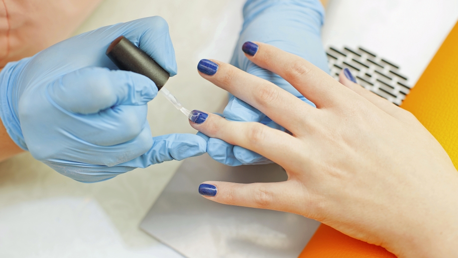manicurist appying nail polish to a client